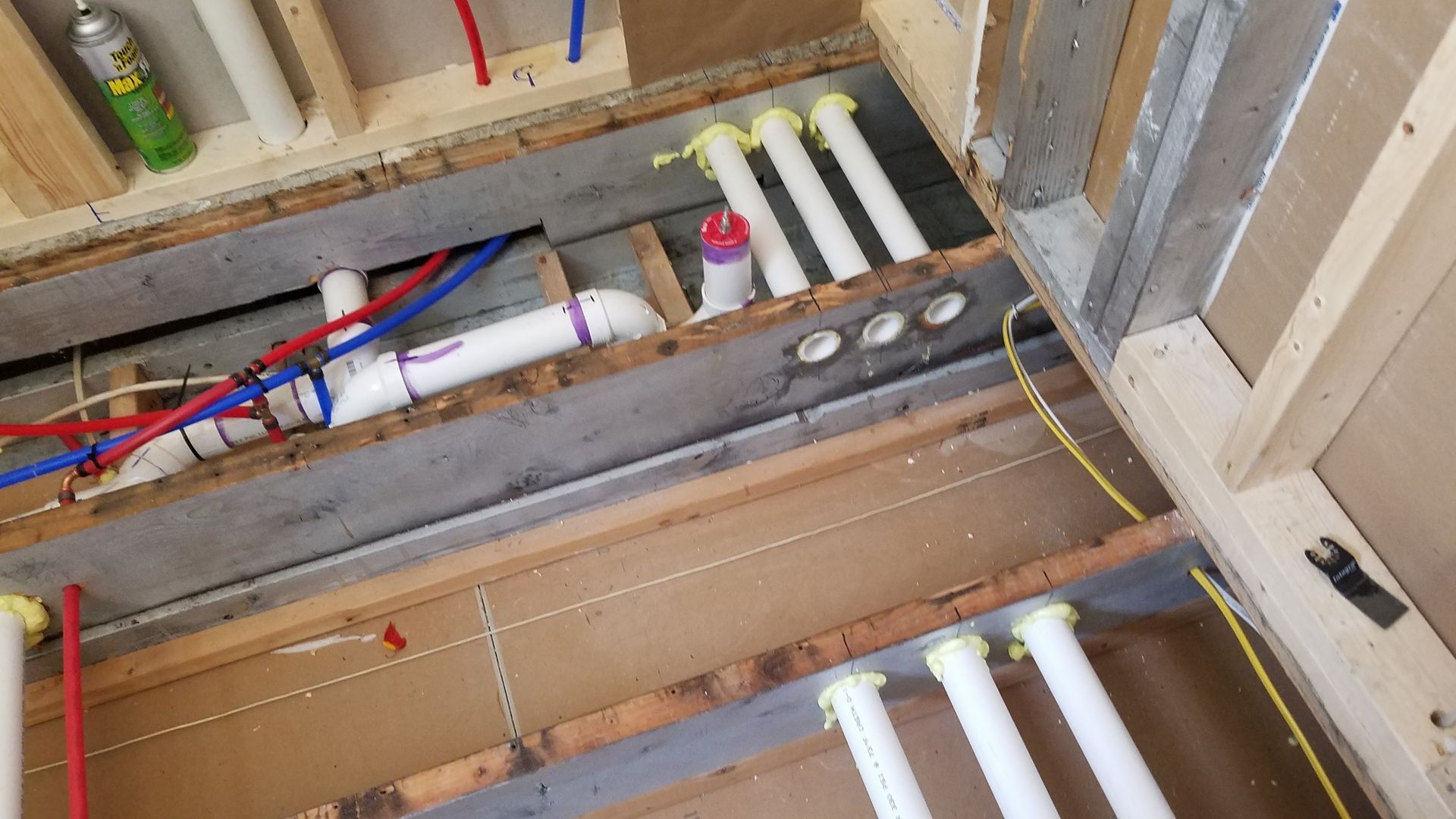 A bunch of pipes are laying on the floor in a room.