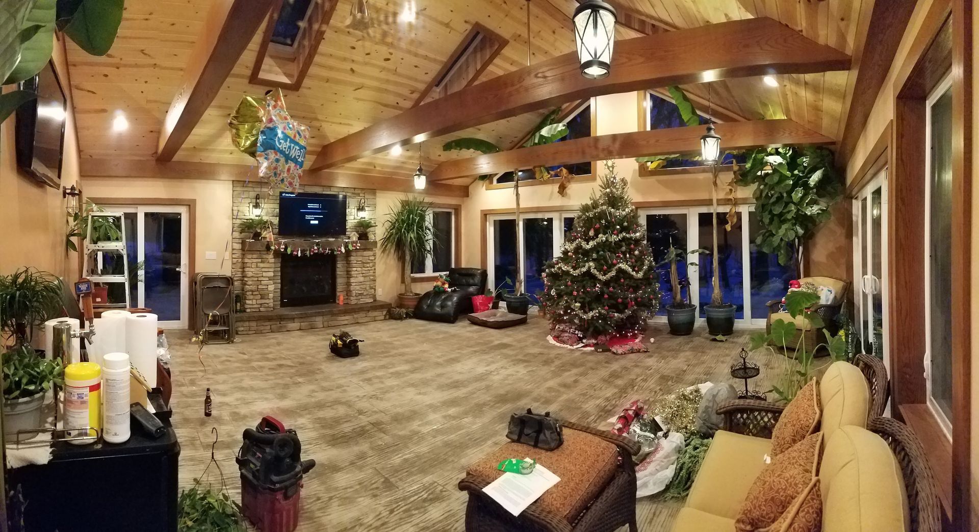 There is a christmas tree in the middle of the living room.