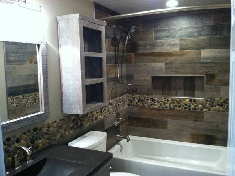 A bathroom with a tub , sink , toilet and mirror