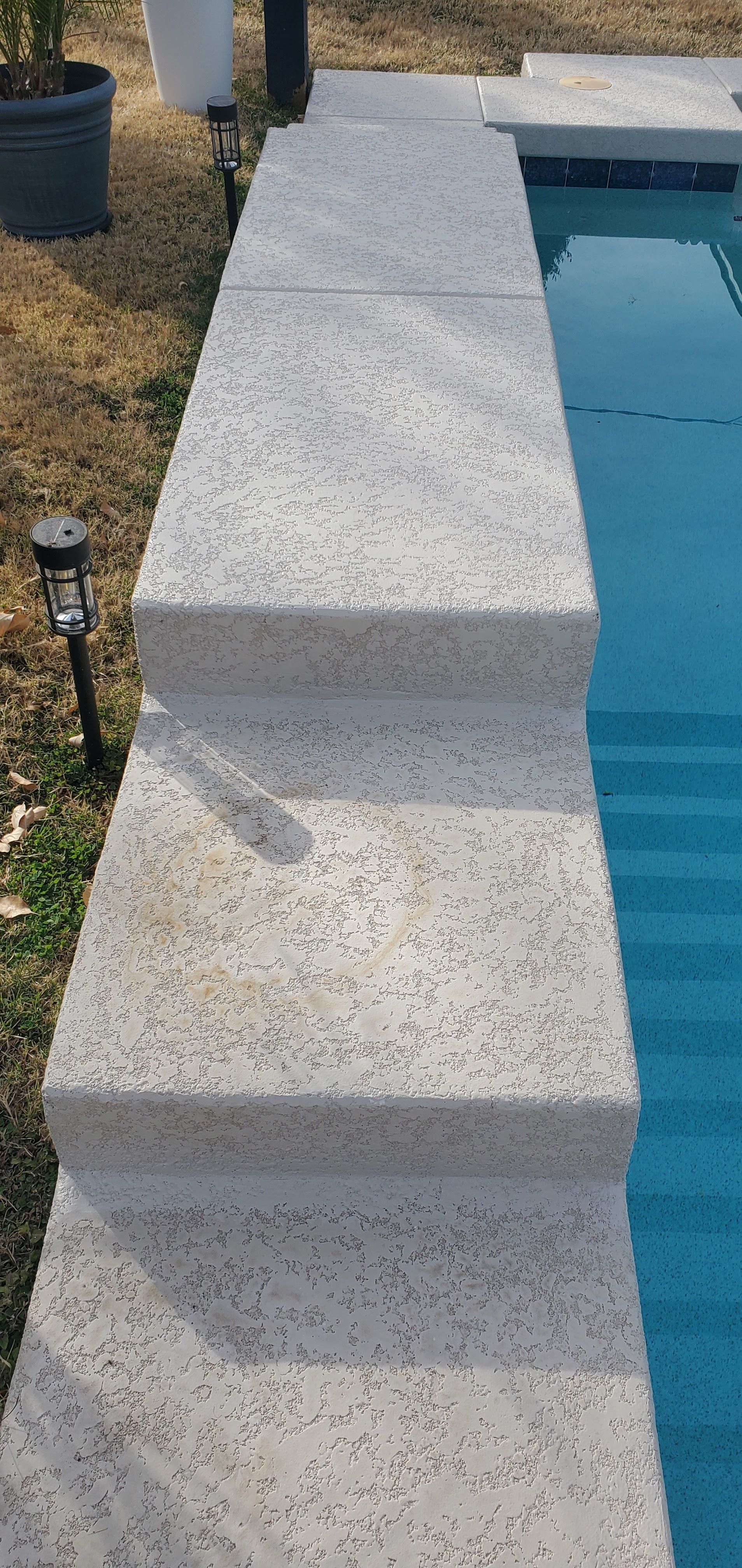 There are stairs leading up to a swimming pool.