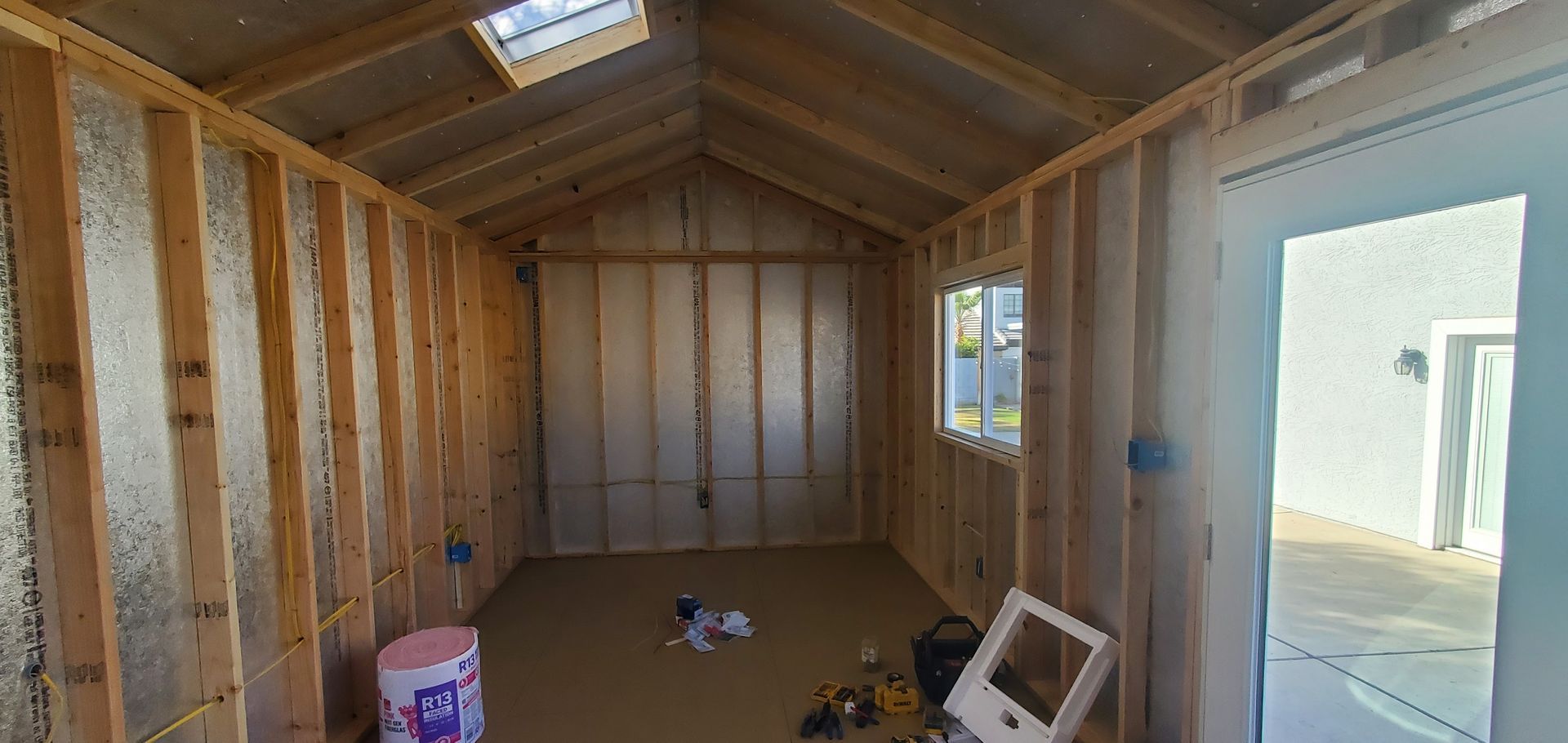 A shed is being built with a skylight and a door.