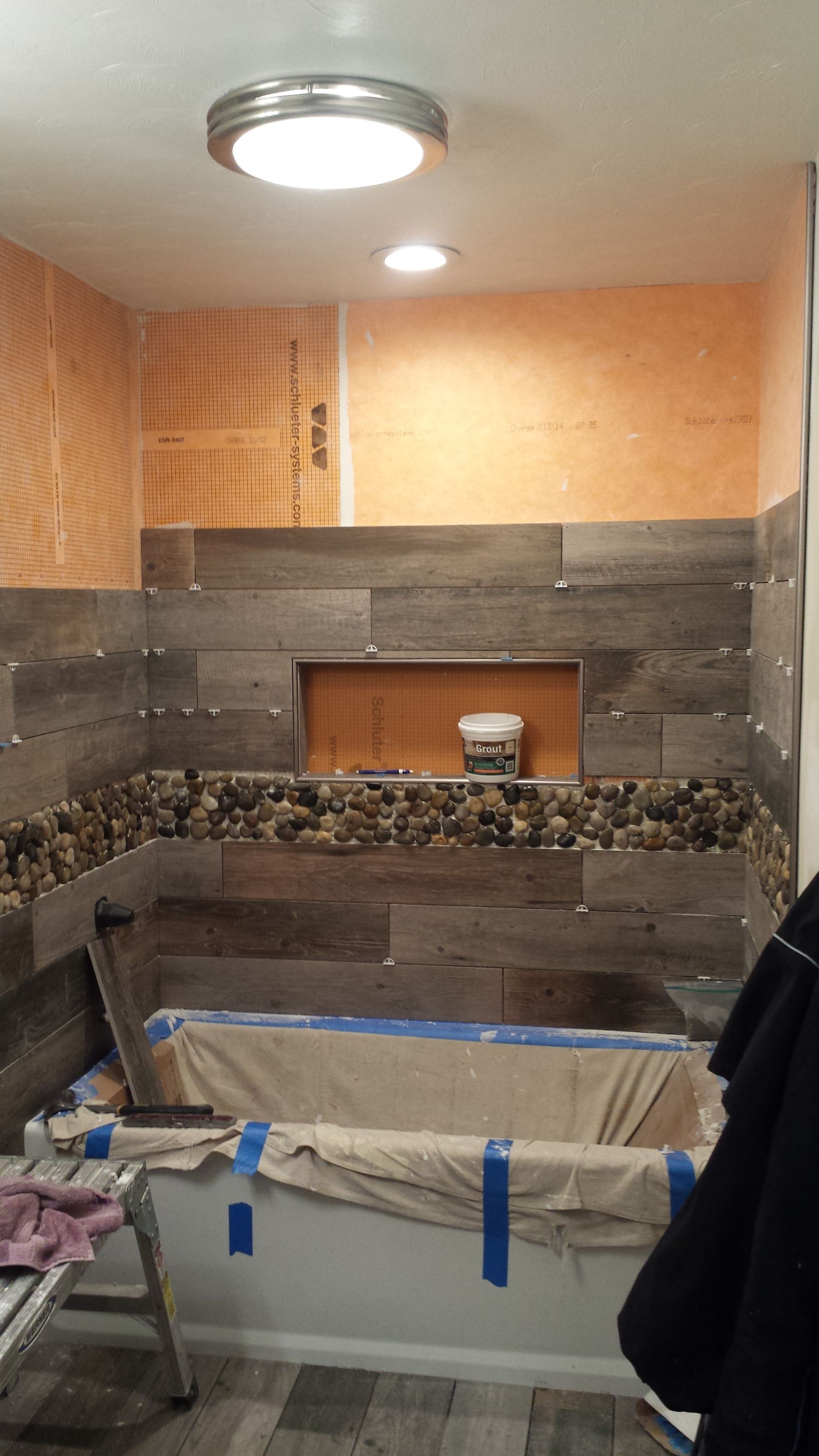 A bathroom with a bathtub and a light on the ceiling.