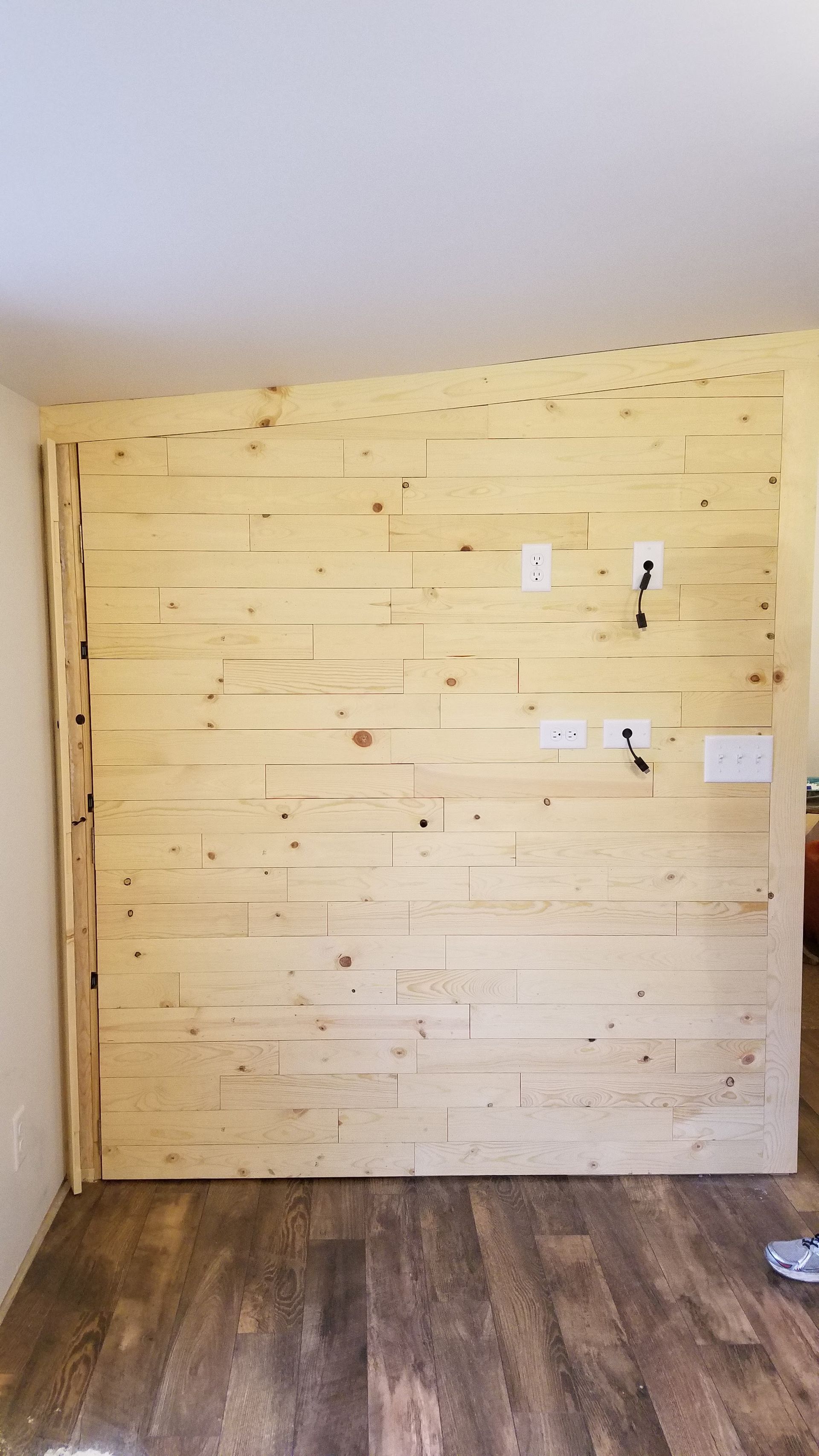 A room with a wooden wall and a wooden floor.