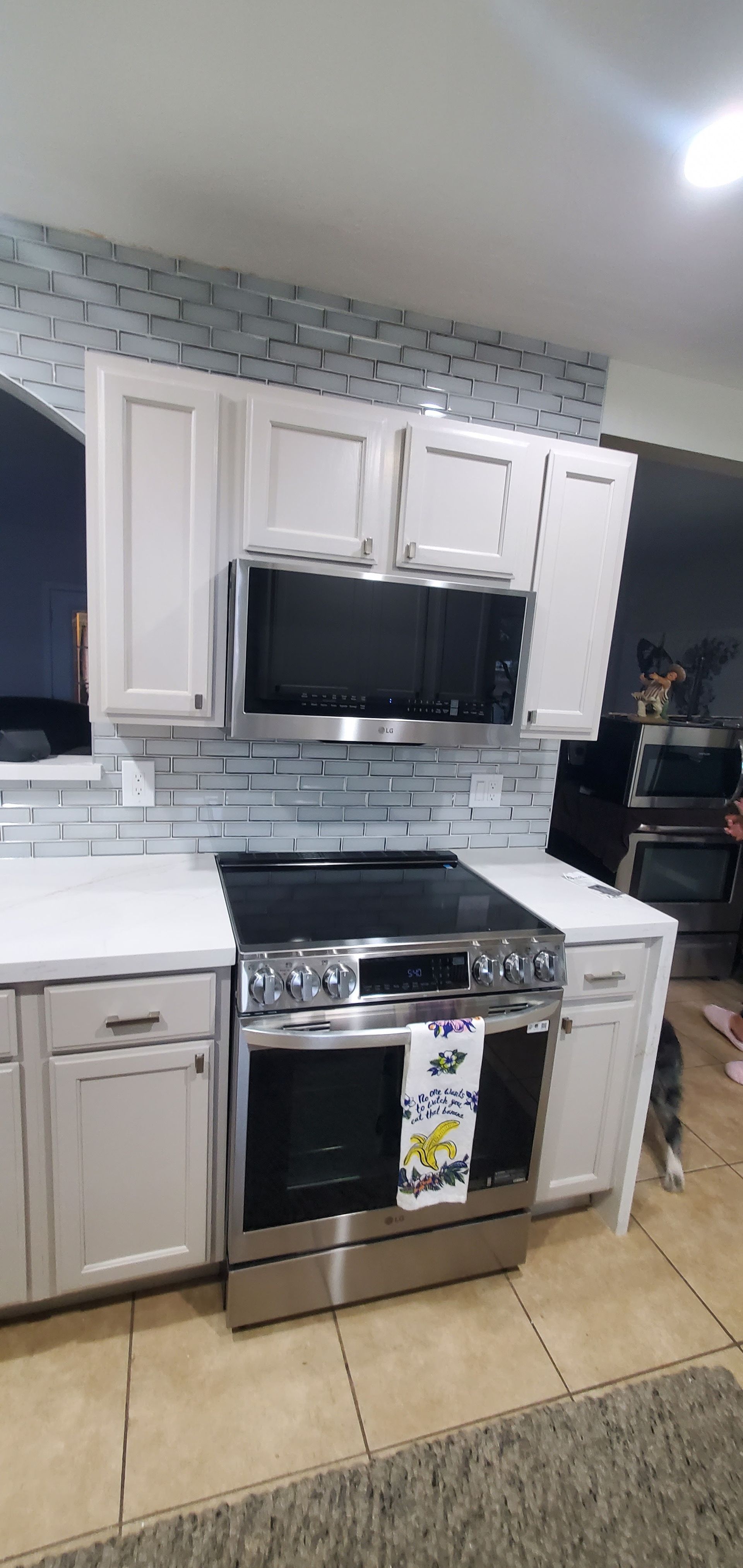 A kitchen with stainless steel appliances and white cabinets.