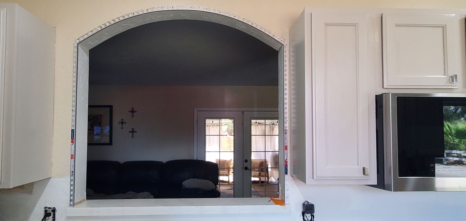 A view of a living room through a window in a kitchen