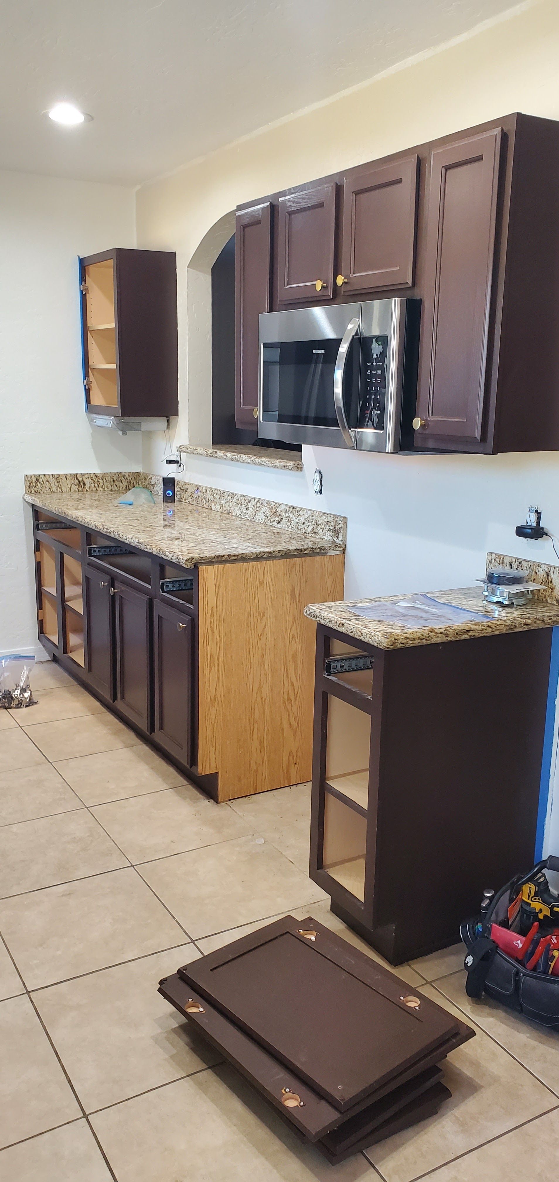 A kitchen with brown cabinets and granite counter tops is being remodeled.