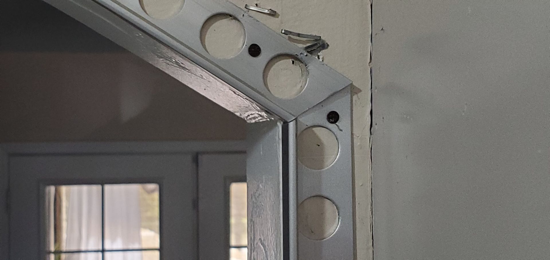 A close up of a metal frame on a wall next to a door.