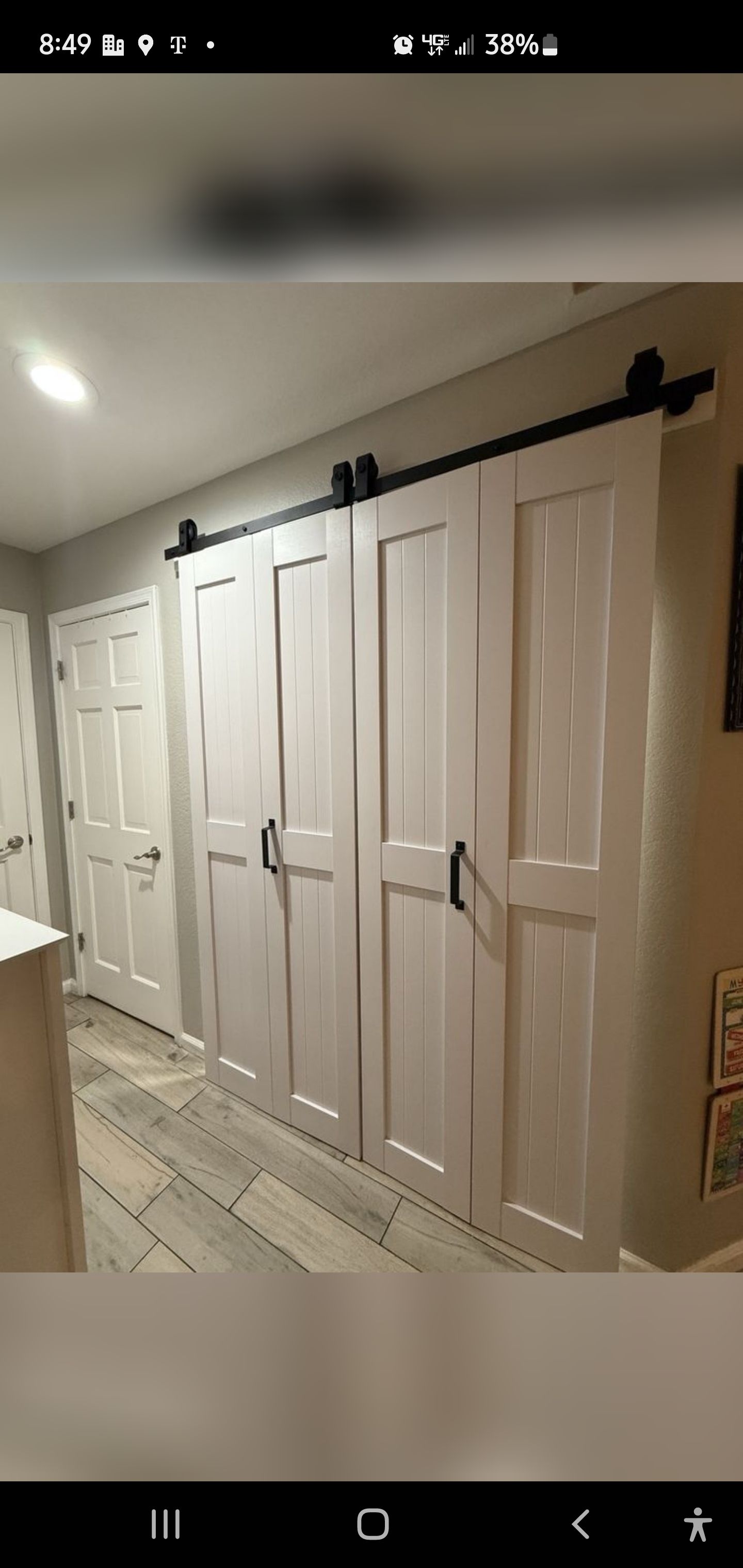 A row of white sliding barn doors in a hallway.
