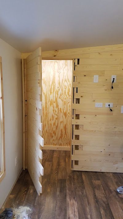 A room with a wooden door and a wooden floor.