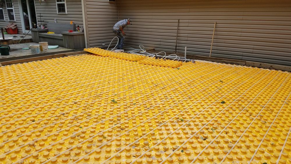 A large yellow mat is laying on the ground in front of a house.