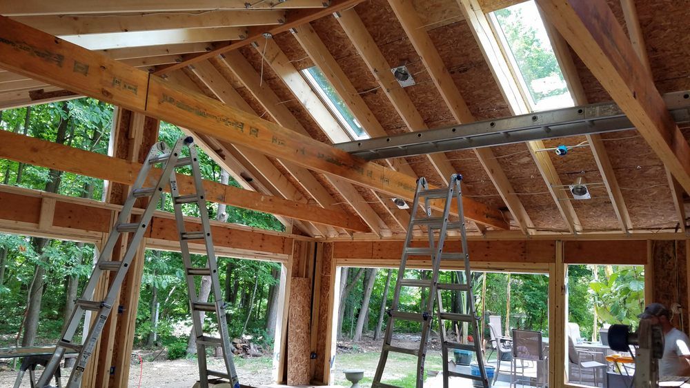 A ladder is hanging from the ceiling of a building under construction.