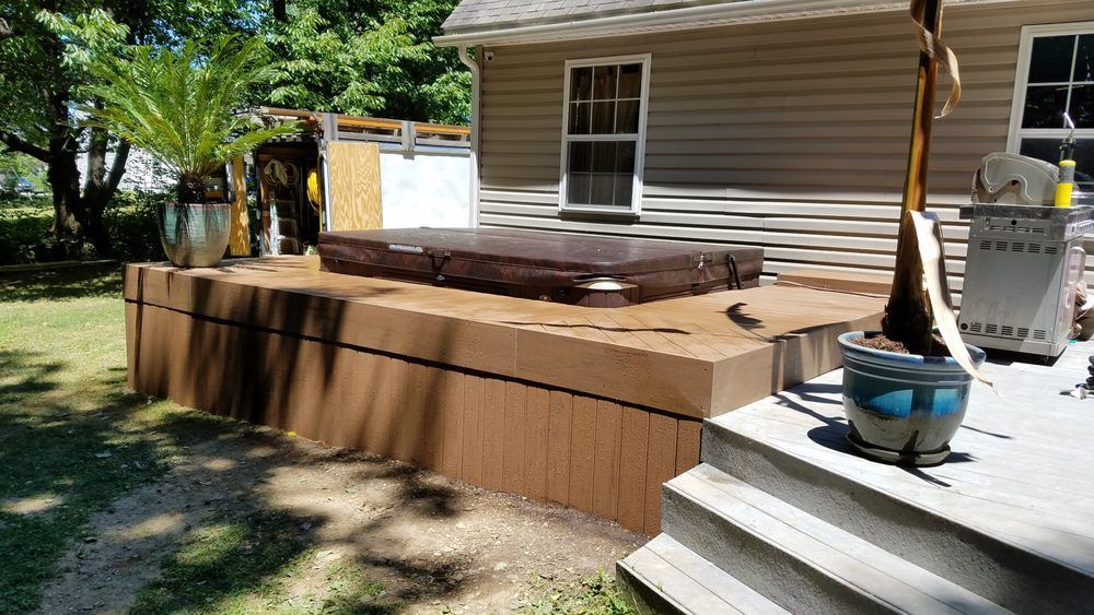 A hot tub is being built in the backyard of a house.