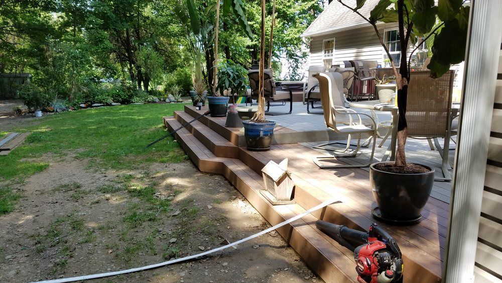 A lawn mower is sitting on a patio next to a house.