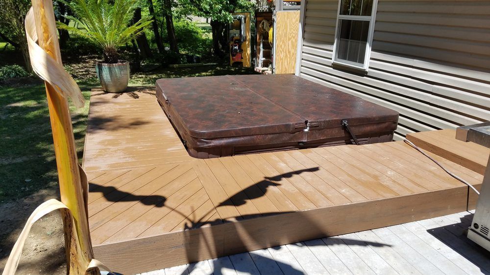 A hot tub is sitting on top of a wooden deck.
