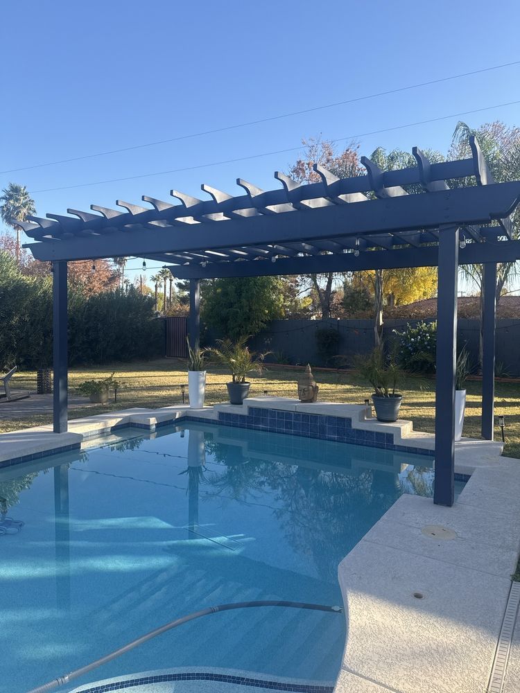A large swimming pool with a pergola over it