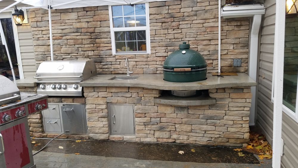 An outdoor kitchen with a grill and a green egg