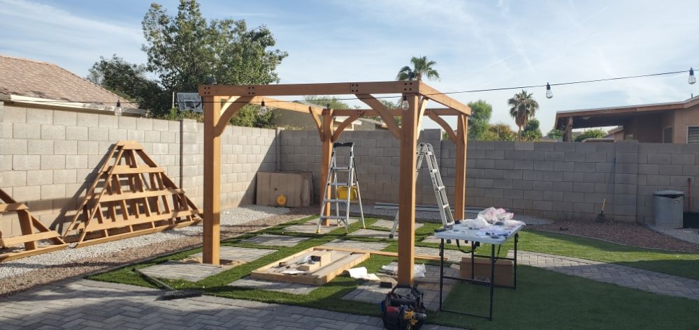 A wooden structure is being built in a backyard.