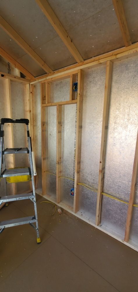 A ladder is sitting in a room under construction.