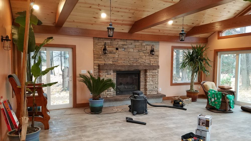A living room with a fireplace and a vacuum cleaner in it.