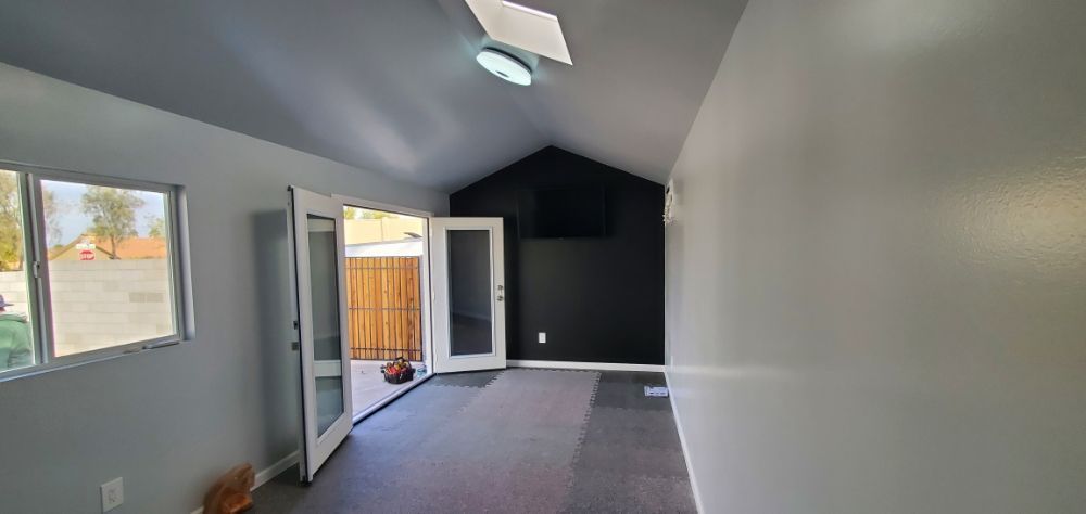 A room with a lot of windows and doors and a skylight on the ceiling.
