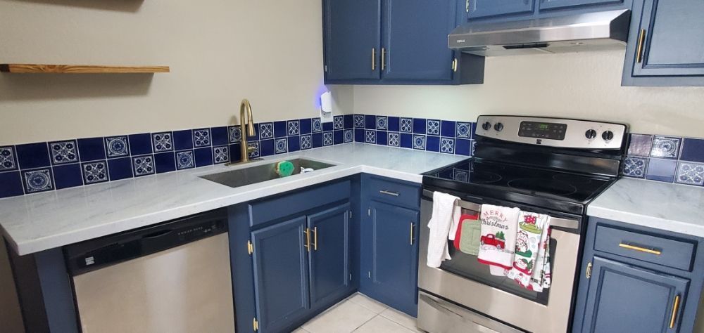 A kitchen with blue cabinets and stainless steel appliances