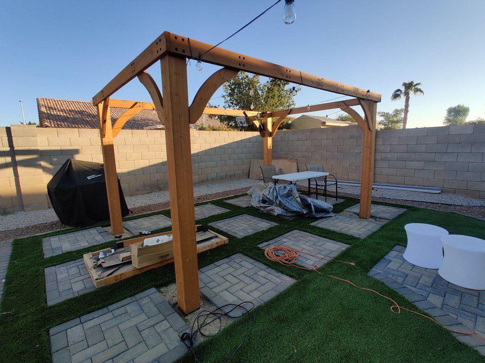 A wooden pergola is being built in a backyard.