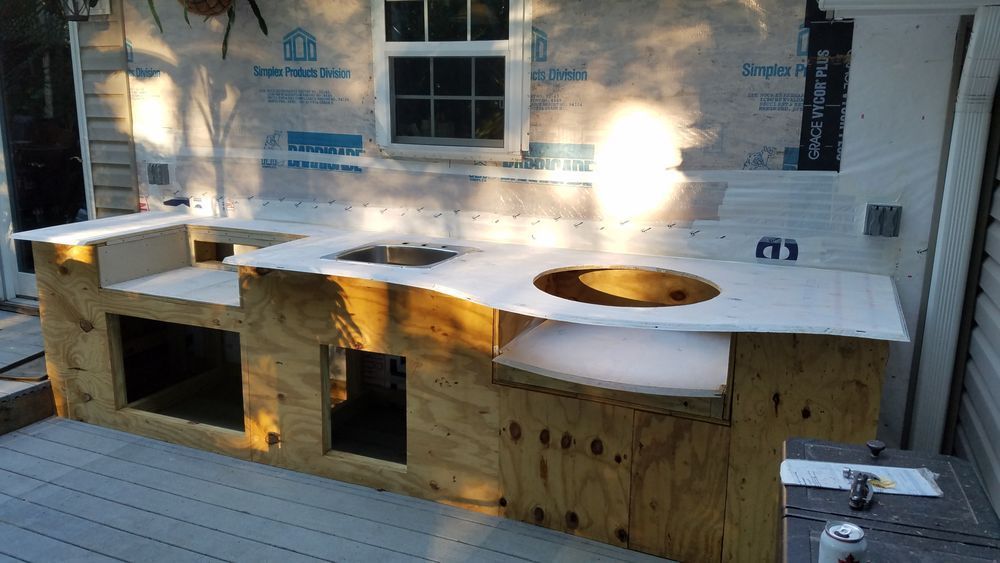 A wooden counter with a sink and a window in the background.