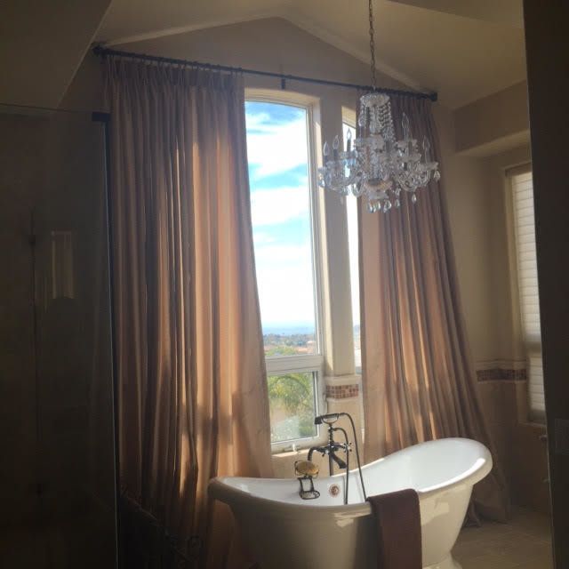 A luxurious bathroom with a freestanding bathtub beneath a window,