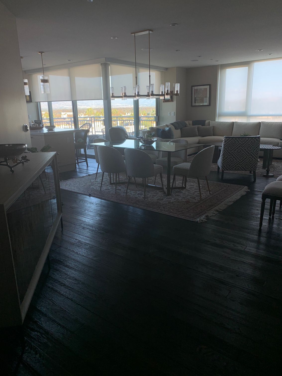 A modern, open-concept living space with a dining table, chairs, and a larg