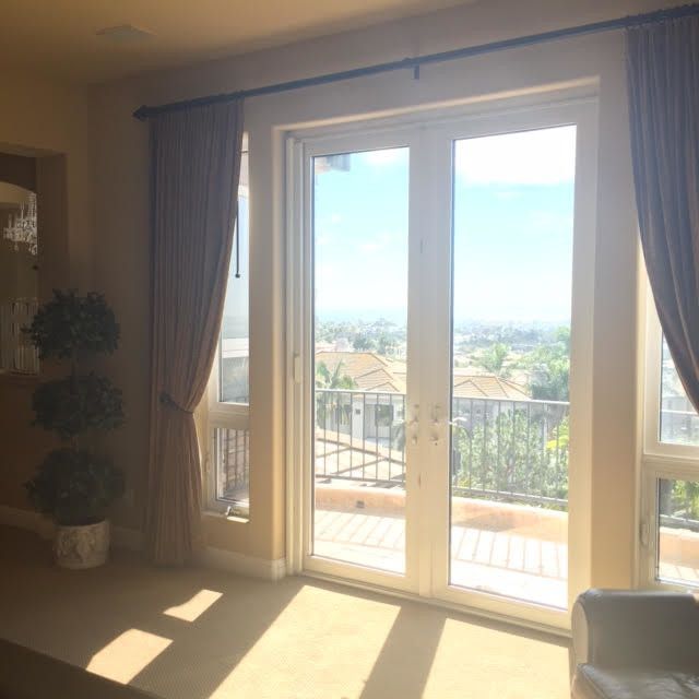 Bright, airy interior with large glass doors leading to a balcony with a scenic, distant view.