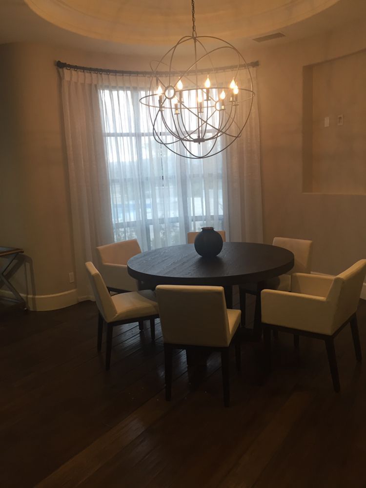 Dining room with a round table, five white chairs, and a large spherical