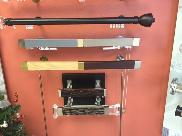 Curtain rods on display: black rod with finial, two-tone rectangular r