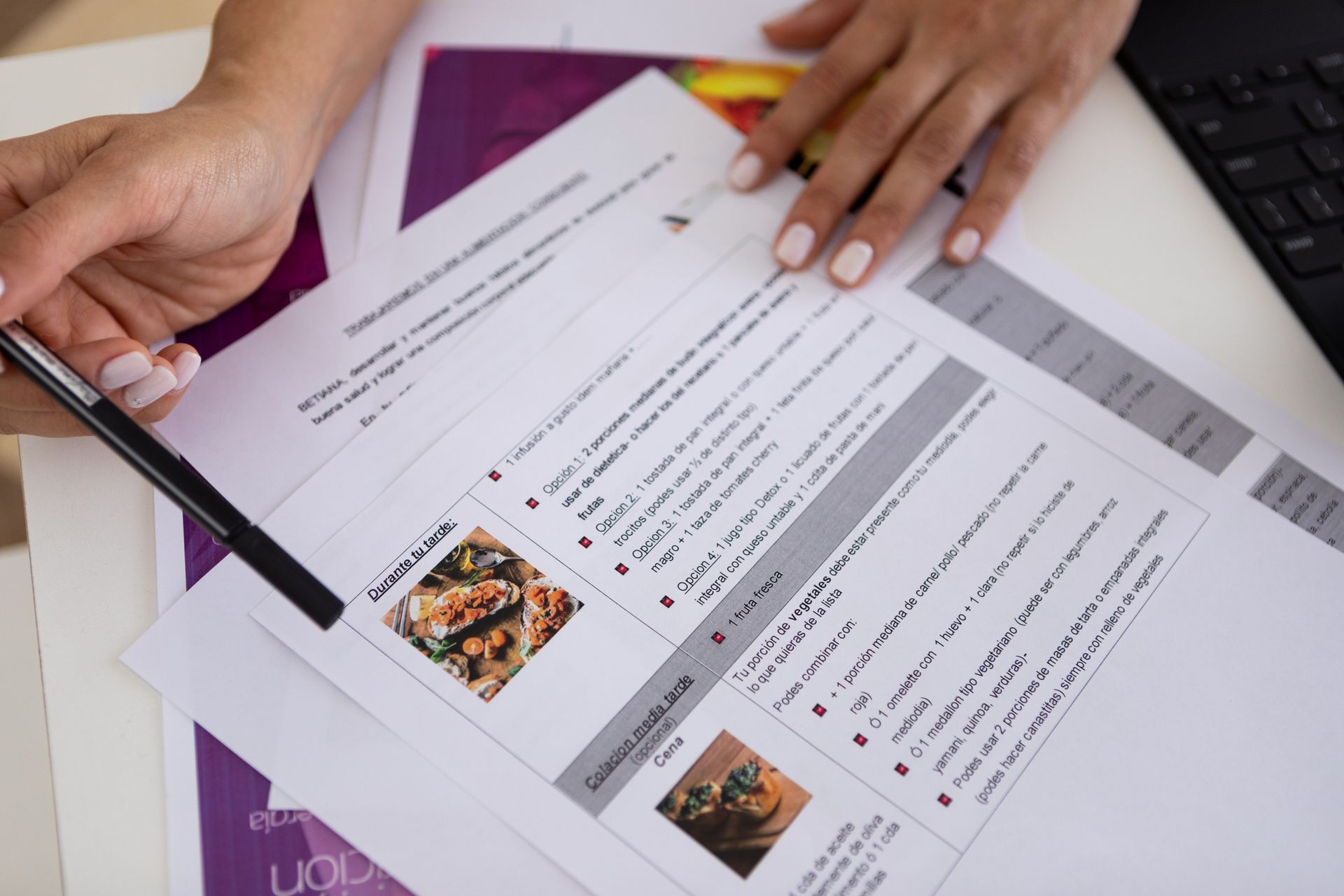 A person is holding a pen over a nutrition plan