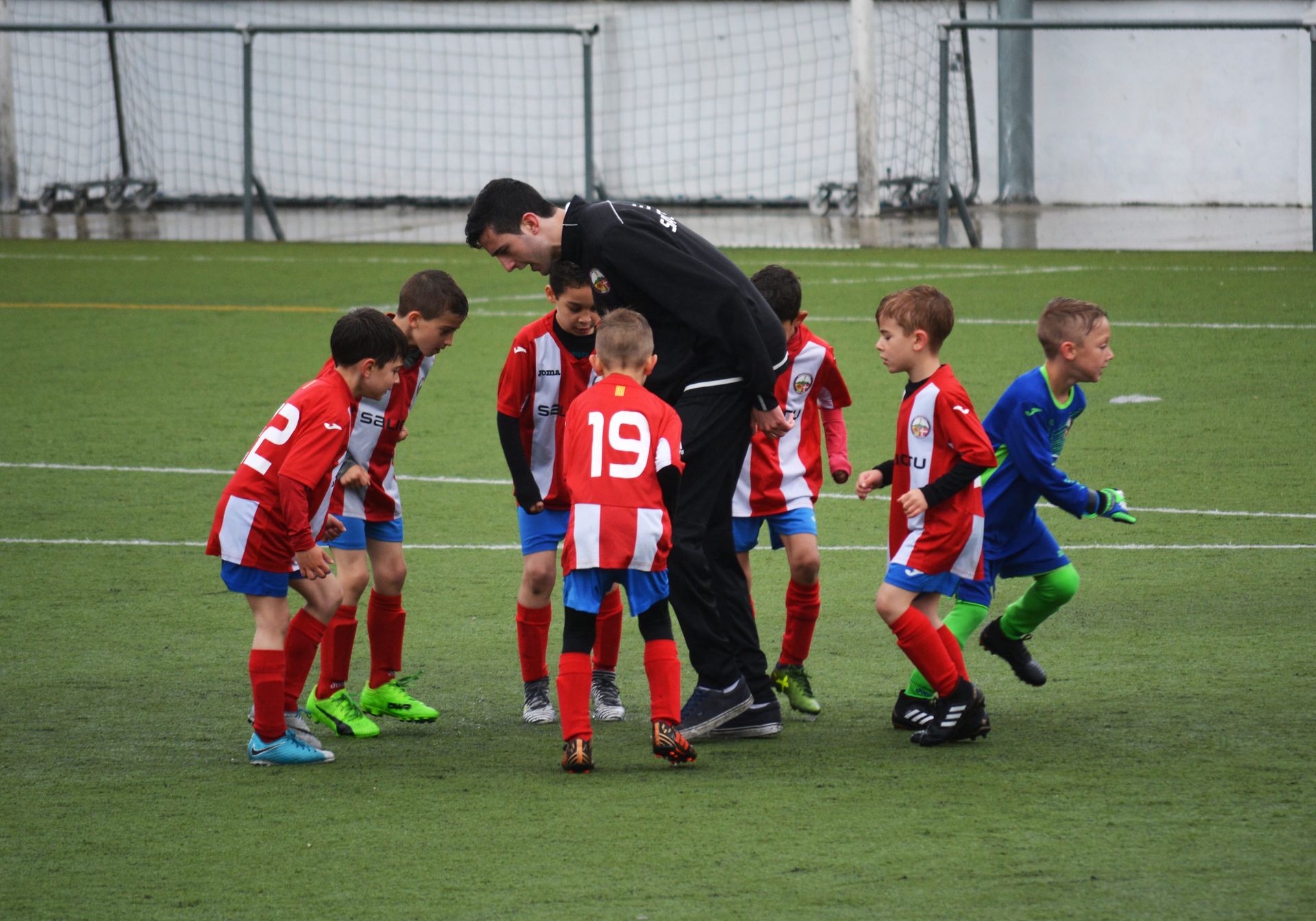 A group of young boys are playing soccer and one of them has the number 19 on his back.