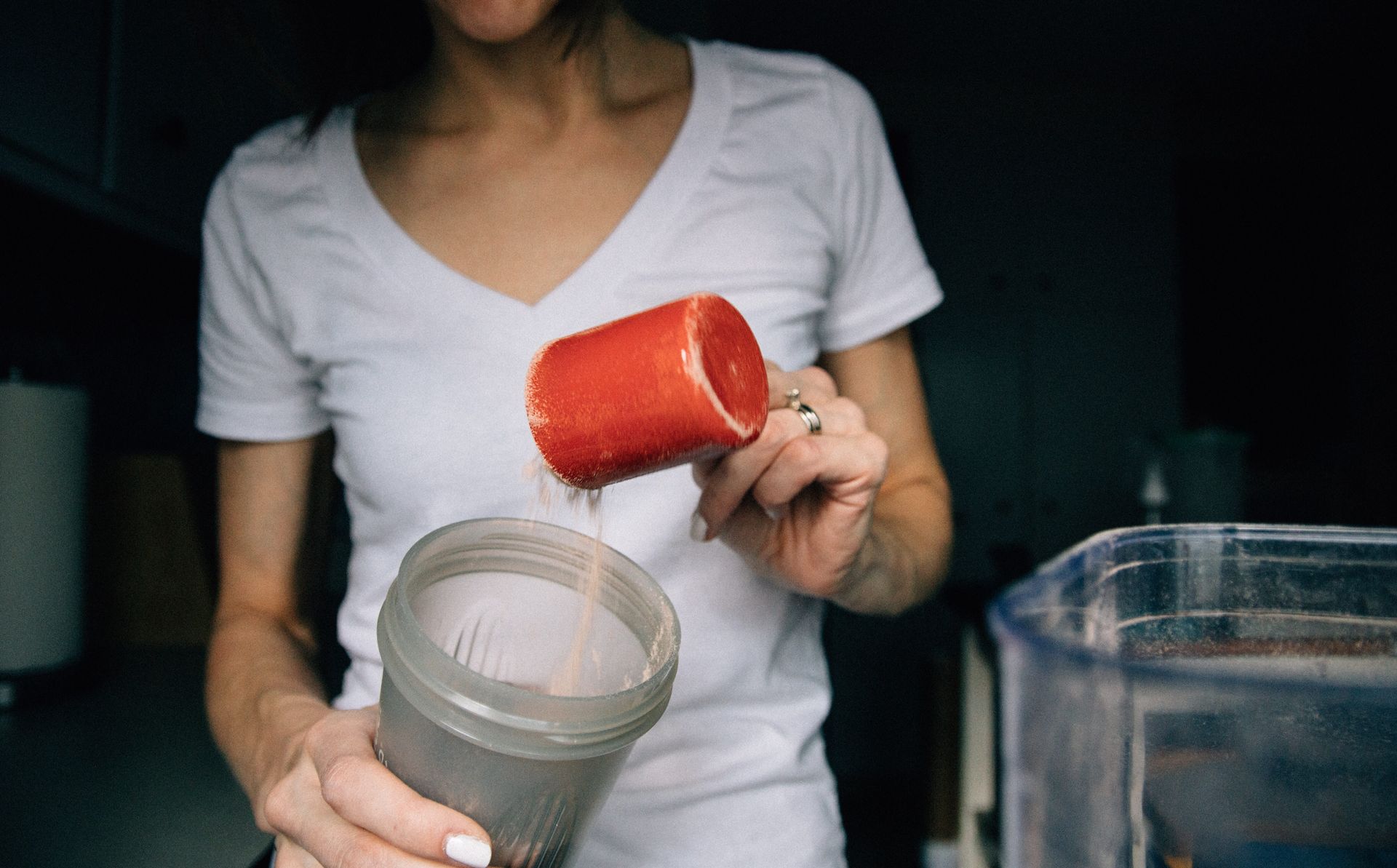 A woman is pouring watermelon into a blender.