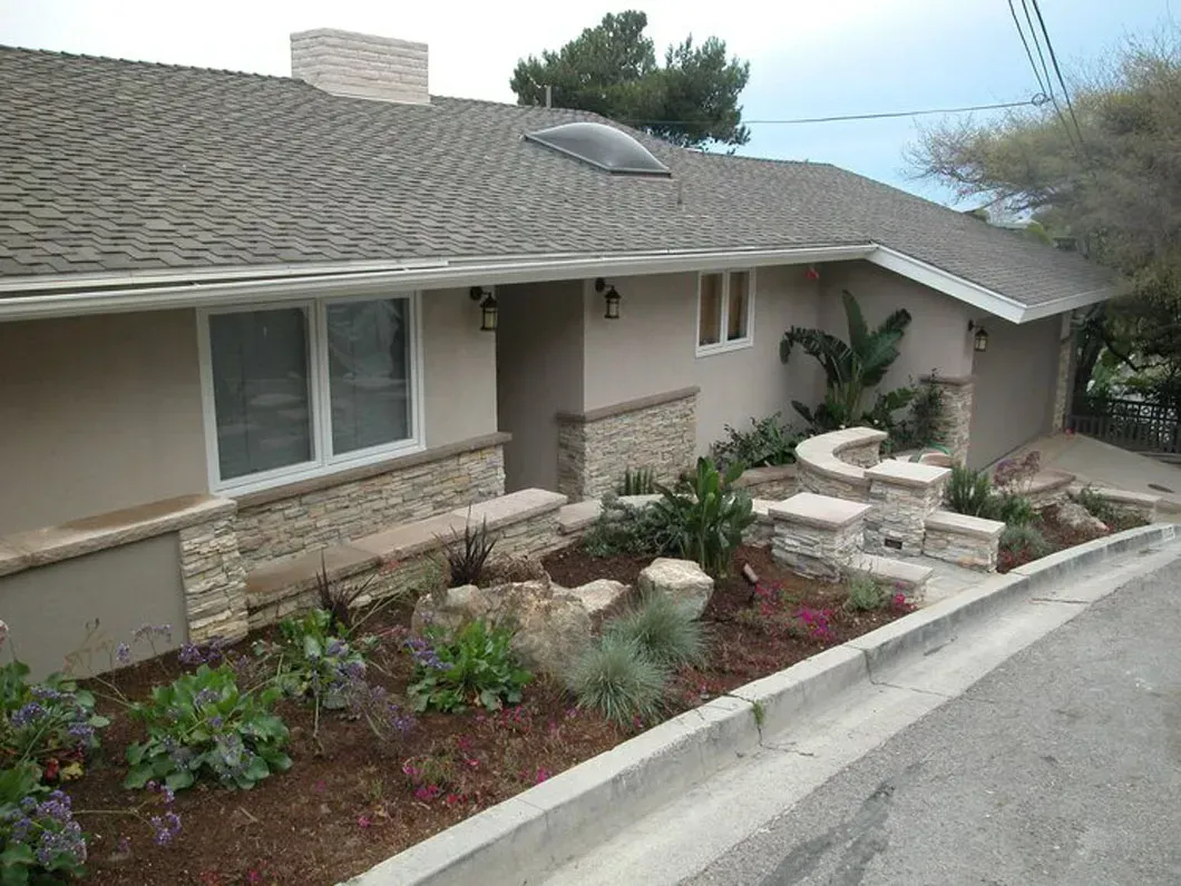 Beige house with a landscaped front yard and stone accents.
