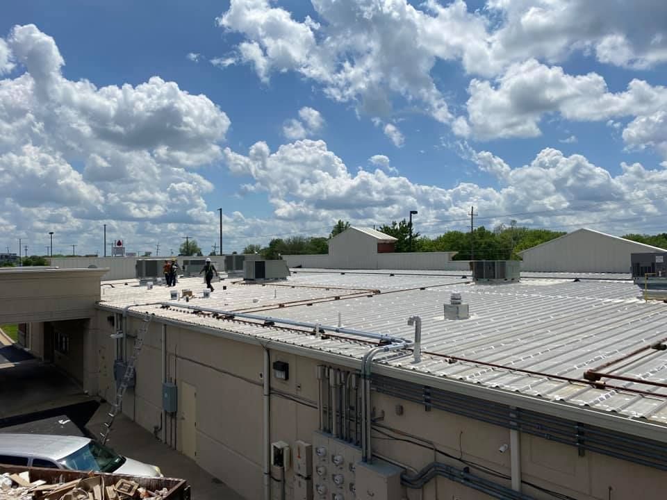 A group of people are working on the roof of a building.