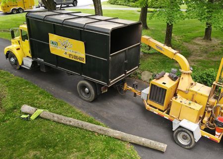A truck with a crane on top of it is working on a power line.