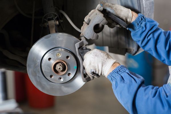 A person is fixing a brake disc on a car.