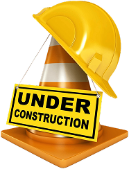 Casque de sécurité jaune sur un cône de signalisation orange avec un panneau « EN CONSTRUCTION ».