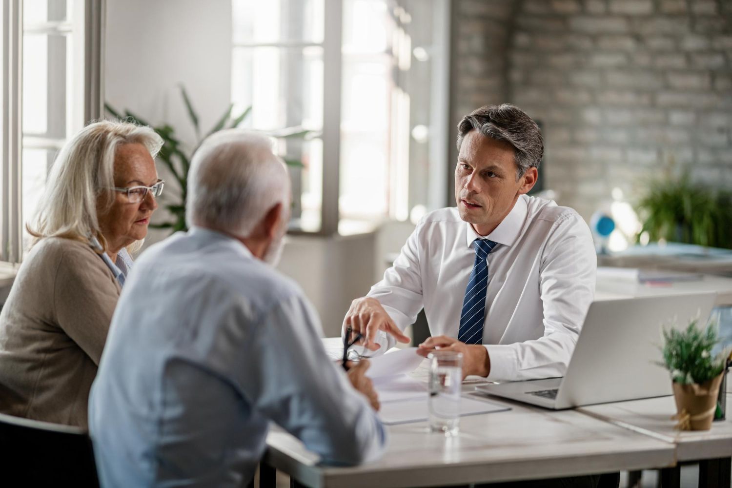 Two business professionals in suits reviewing documents, discussing strategy.