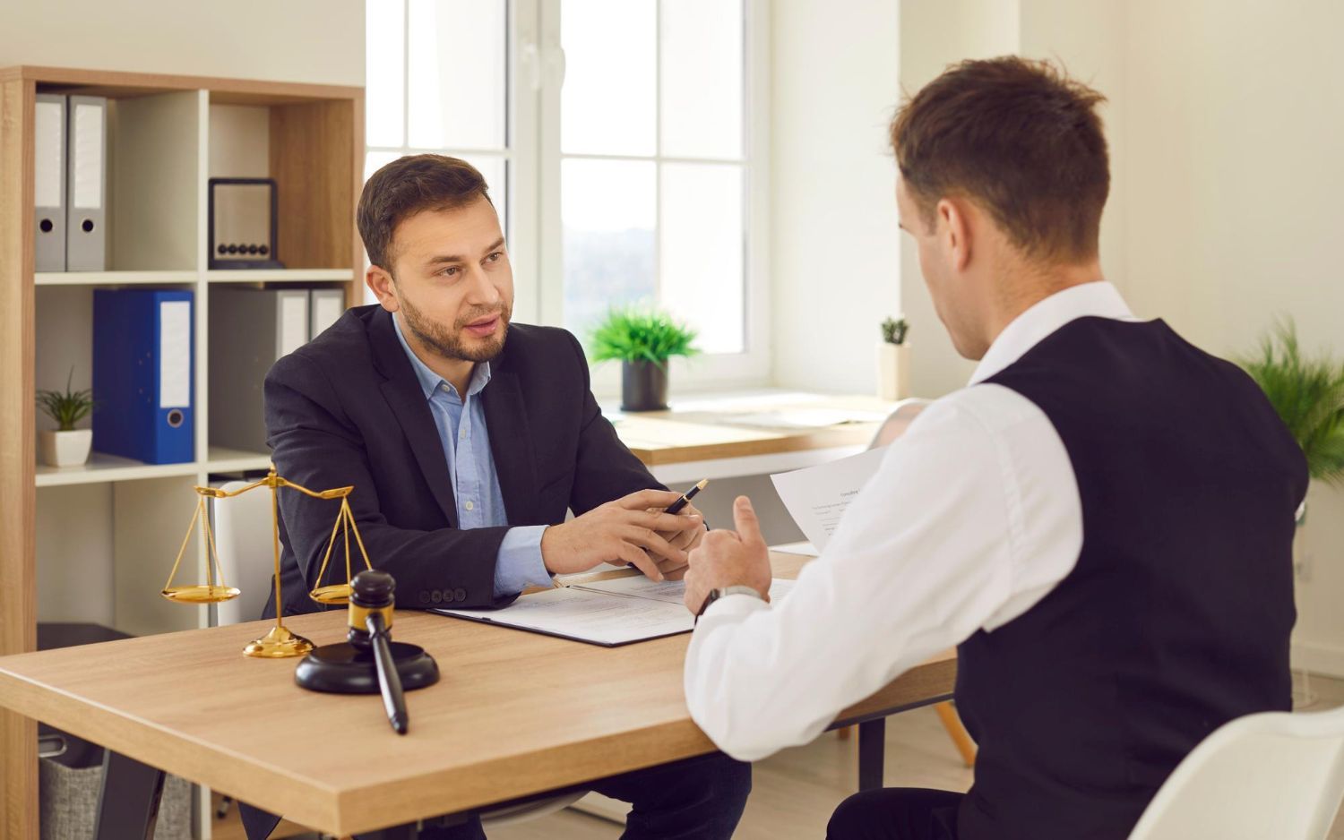 Two business professionals in suits reviewing documents, discussing strategy.