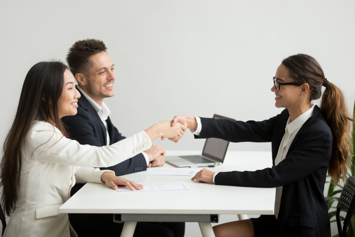 Two business professionals in suits reviewing documents, discussing strategy.