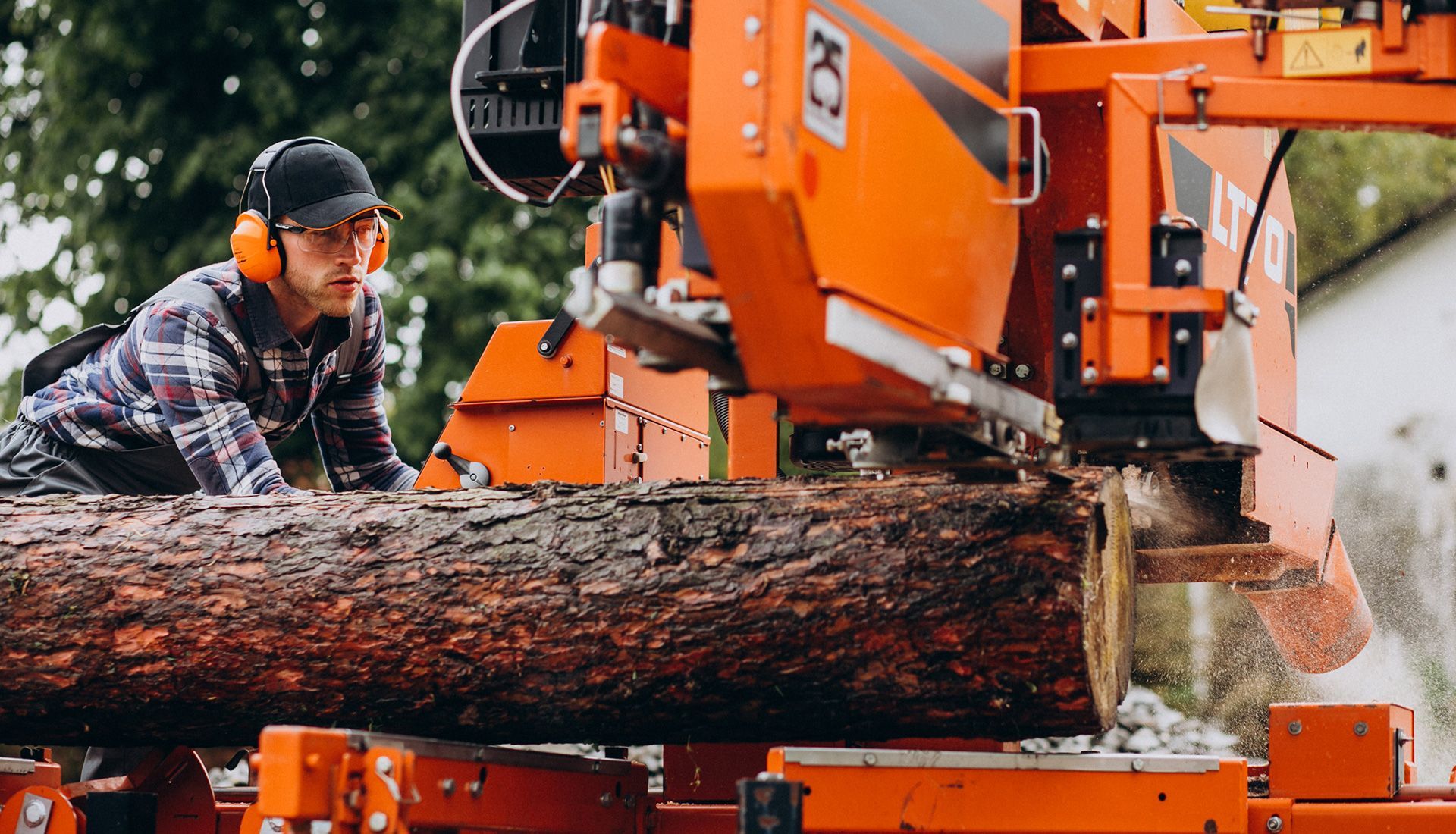 A man is cutting a log with a machine.