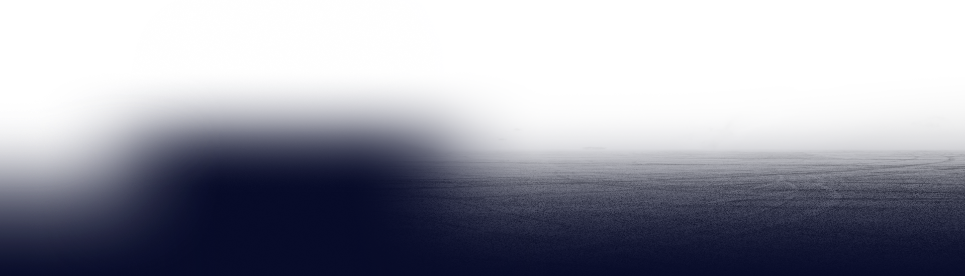 A dark, horizontal expanse with a blurred, hazy light gradient at the top, transitioning into a textured, solid base.
