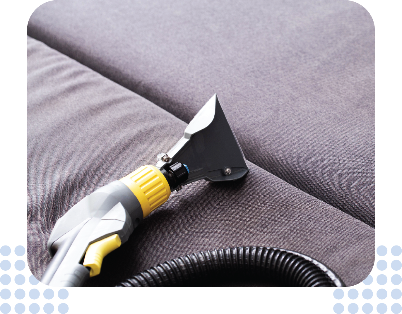 A vacuum cleaner is being used to clean a couch