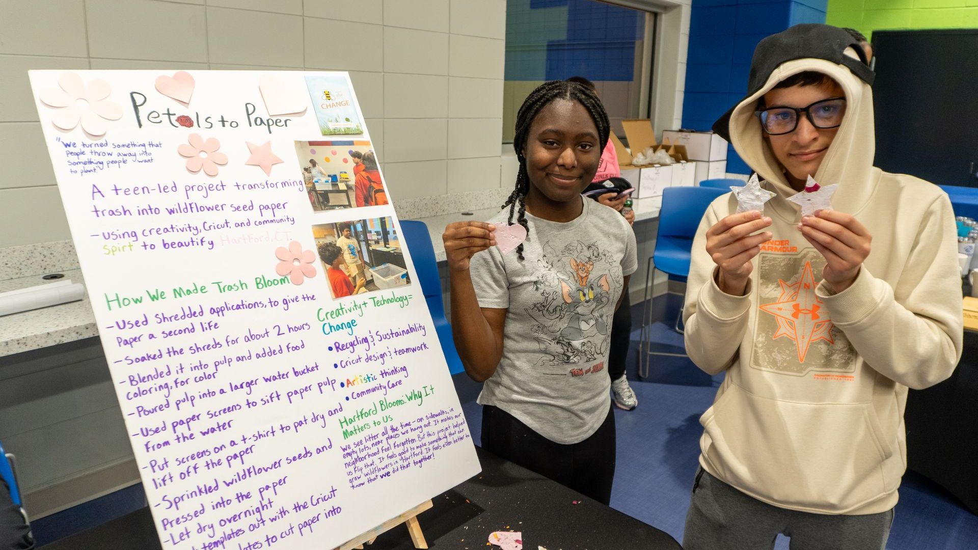 A man and a woman are standing next to each other in front of a sign.
