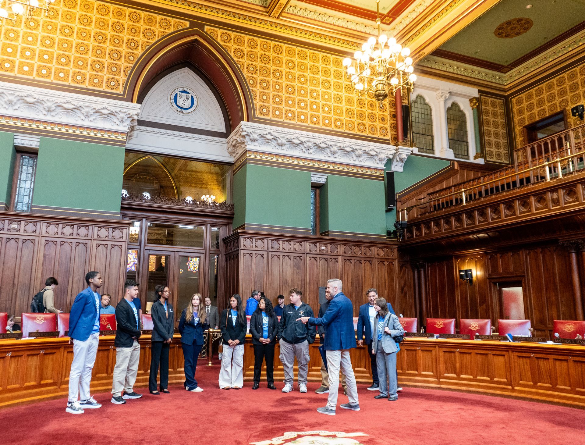 A group of people are standing in a large room in a building.