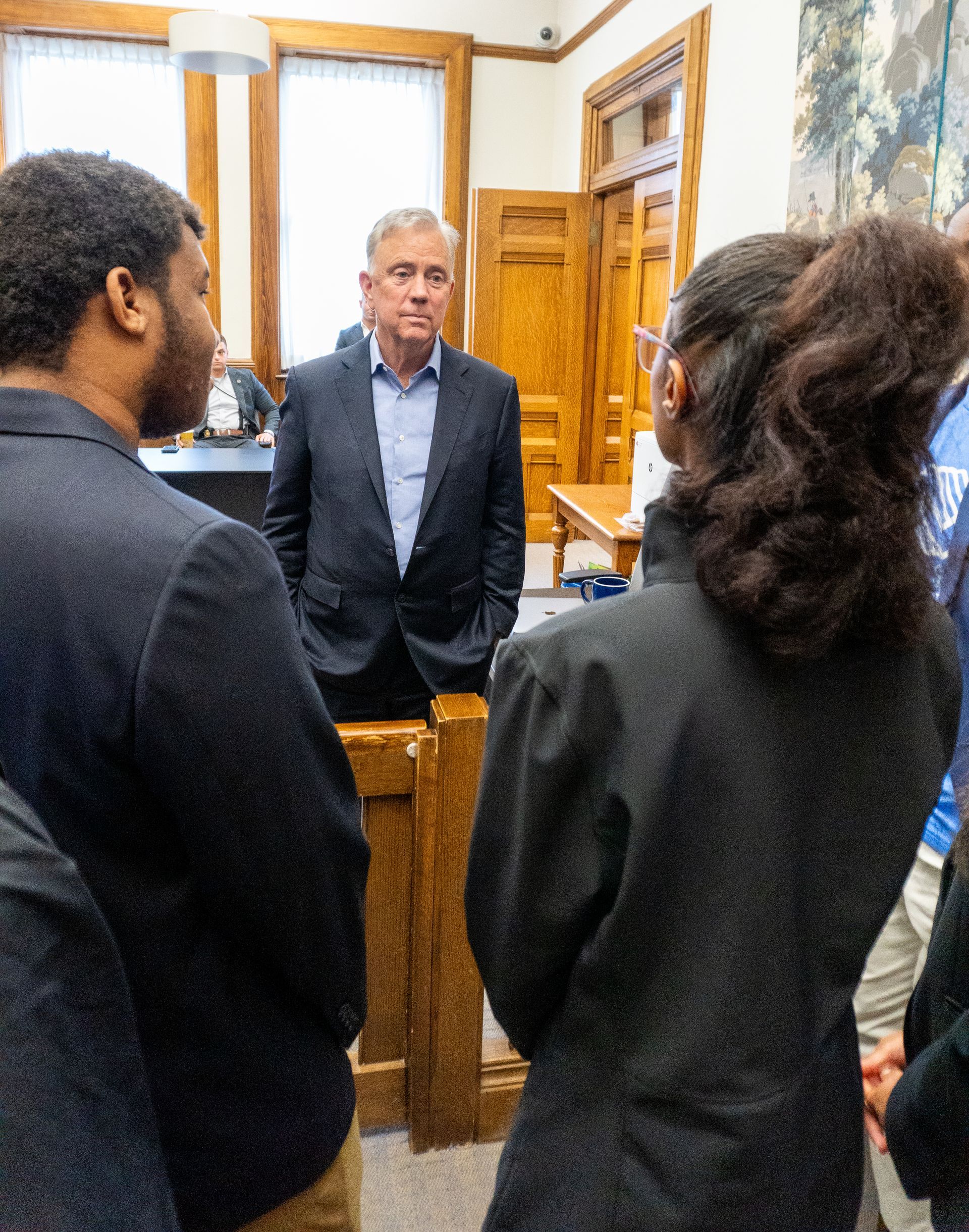 A group of people standing around a man in a suit