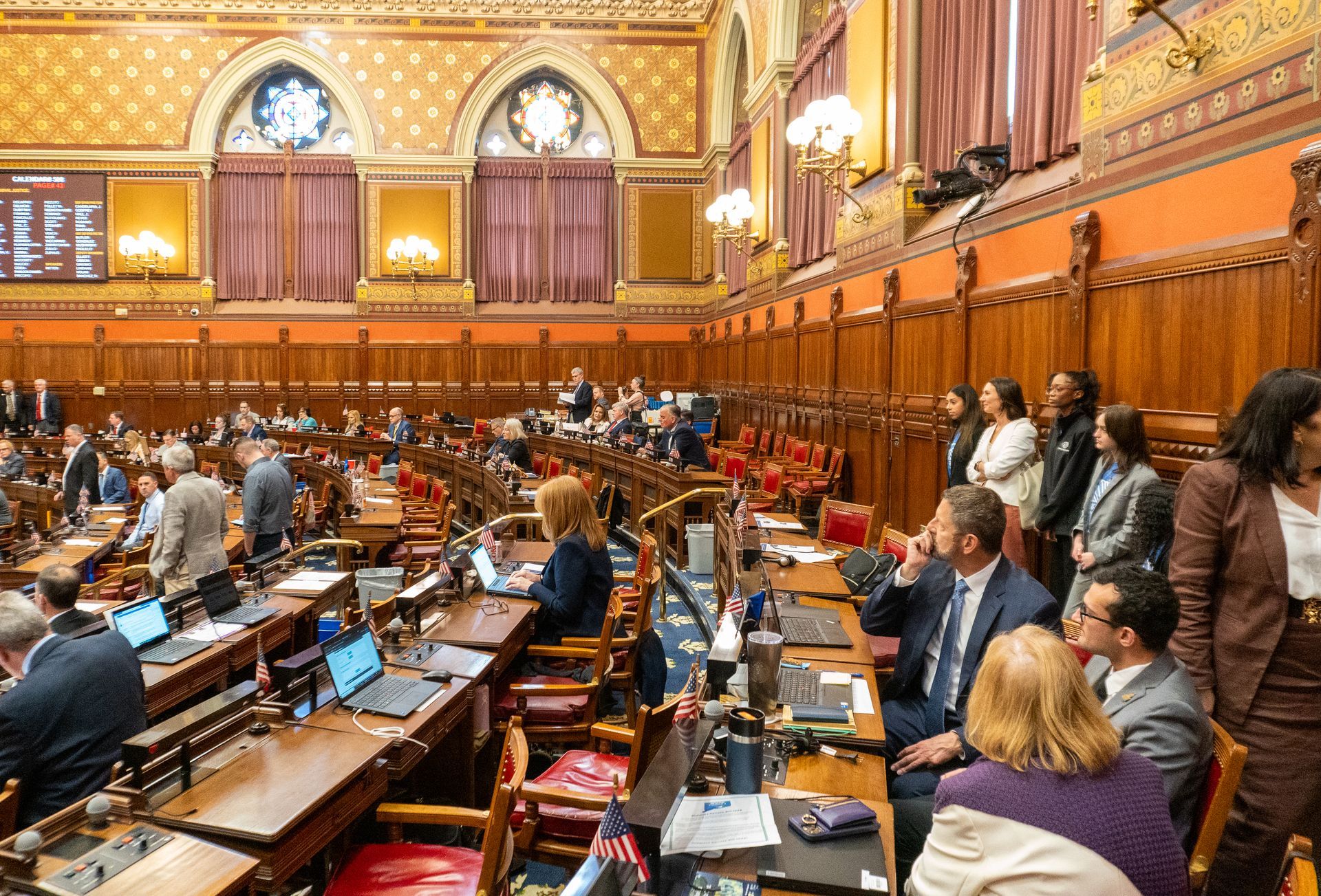 A group of people are sitting at tables in a large room.